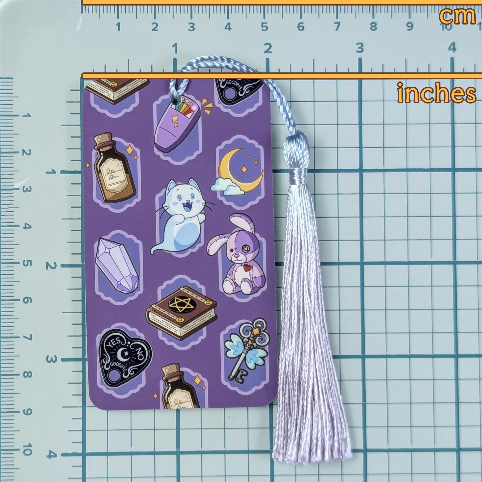 Decorative bookmark with tassel on a grid background with ruler for scale