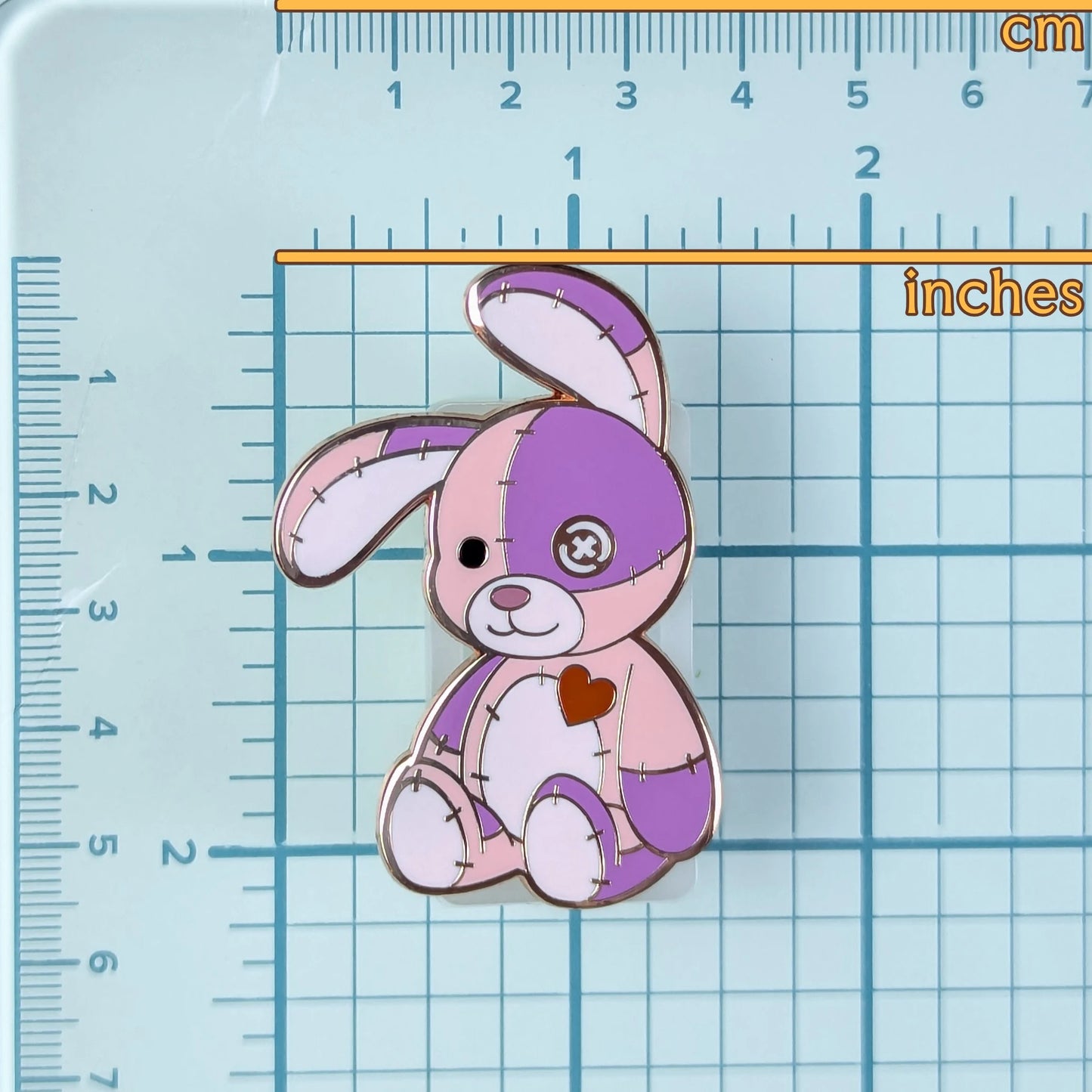 Cute pink & purple patchwork bunny pin on a grid background to show measurements.
