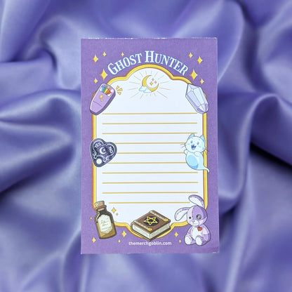 Notepad with 'Ghost Hunter' themed symbols including EMF reader, a ghost cat, cursed stitched bunny, book, potion bottle, gem, and spirit board charm