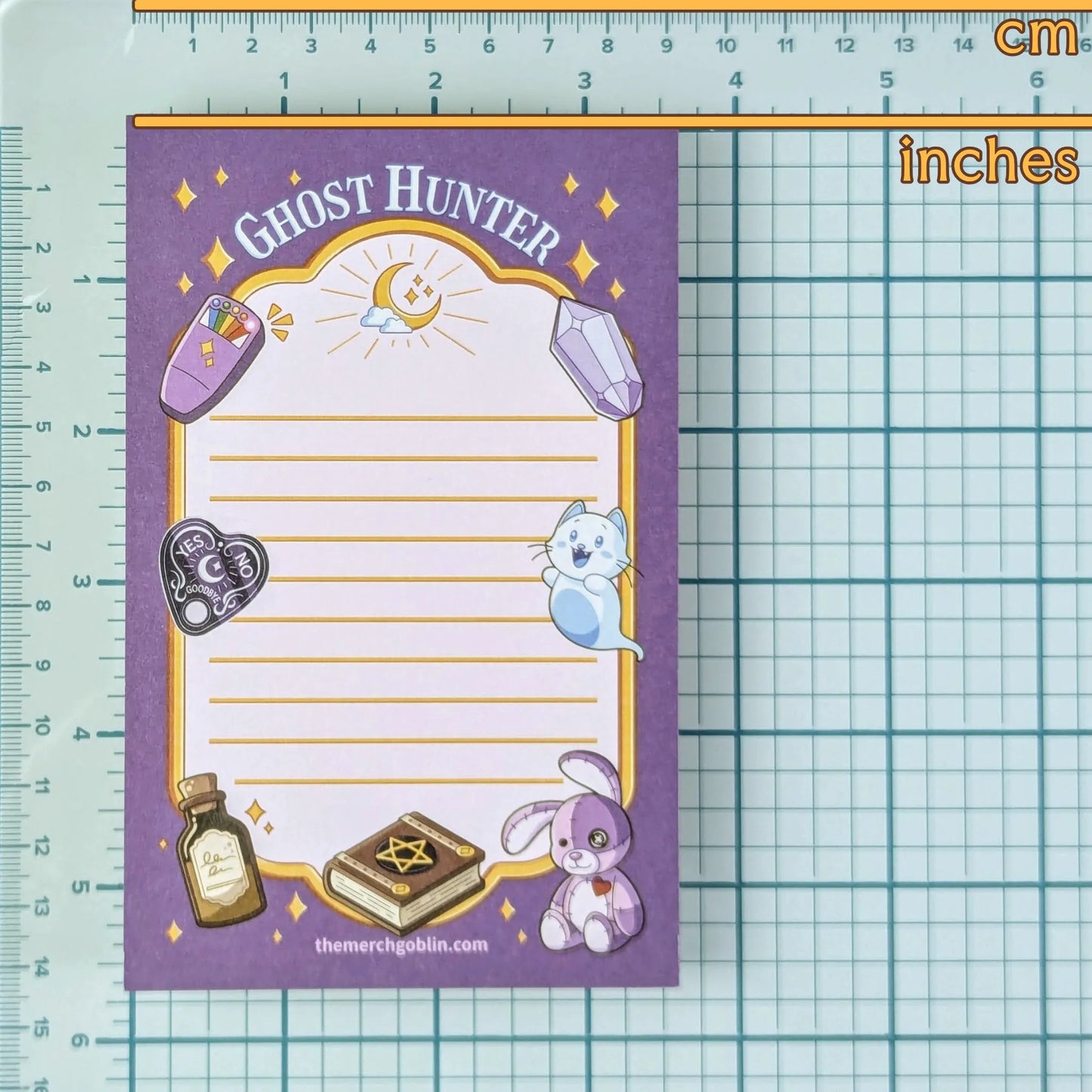 Notepad with 'Ghost Hunter' design on a grid and ruler background