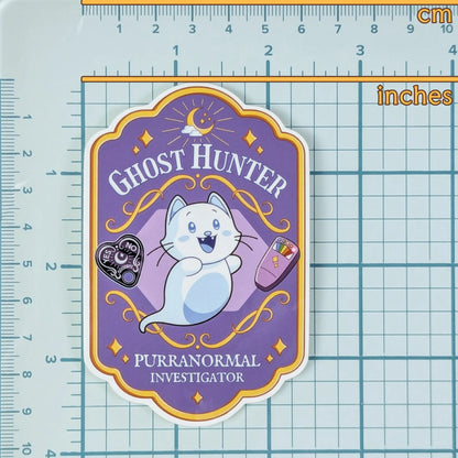 Sticker with a ghost-hunter themed design on a grid background that show measurements.