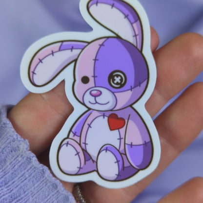 Video of a purple patchwork bunny sticker with a purple silk background
