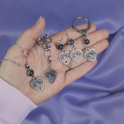 Video of a bracelet, necklace, earrings, and keychain all with heart-shaped spirit board pendant