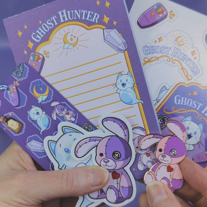 Video of a Ghost Hunter themed stationery set including notepad, hard enamel pin, bookmark, a bunch of stickers, and choice of jewelry