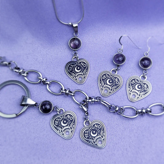 Bracelet, necklace, earrings, and keychain all with heart-shaped spirit board pendant